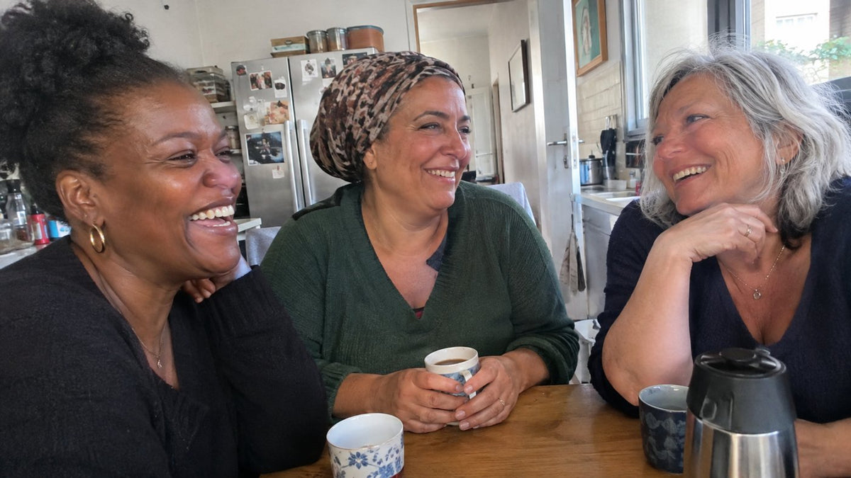Trois amies de 45 à 63 ans qui rient autour d'un café (photo d'illustration)