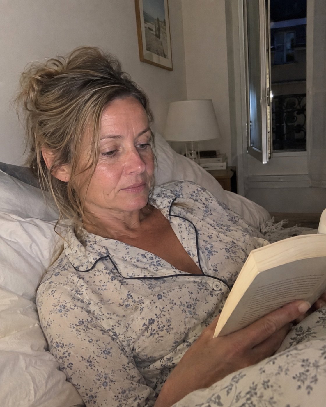 Femme de 53 ans qui lit au lit le soir (photo d'illustration)